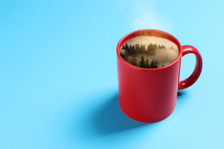 Misty mountain forest in red cup on light blue backgroundの写真素材