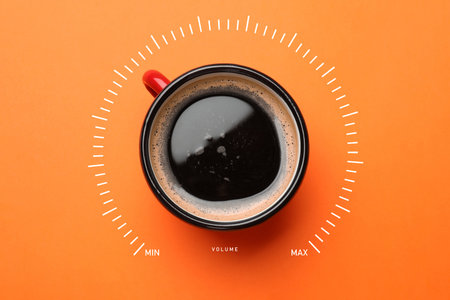 Coffee and volume of energy gauge scale on orange background, top view. Stimulating property of caffeineの写真素材