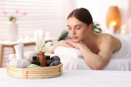 Beautiful woman relaxing on massage couch in spa salon, selective focus