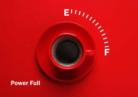 Coffee and power gauge scale on red background, top view. Handle of cup pointing at Full mark. Energizing property of caffeineの写真素材