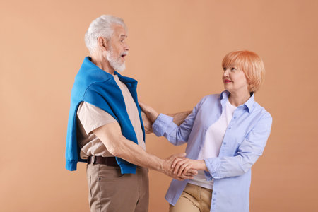 Lovely senior couple together on light brown background