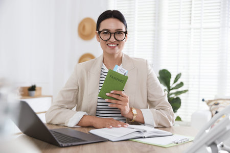 Travel agent with passport and ticket at wooden table in officeの写真素材