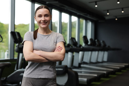 Portrait of personal trainer in sport center. Space for text
