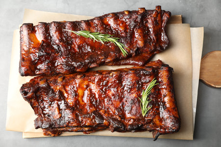 Tasty roasted pork ribs served with rosemary on light grey table, top viewの写真素材