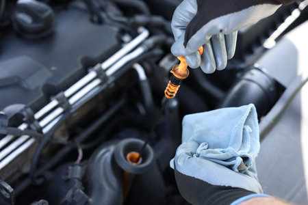 Worker checking motor oil level in car with dipstick, closeupの写真素材