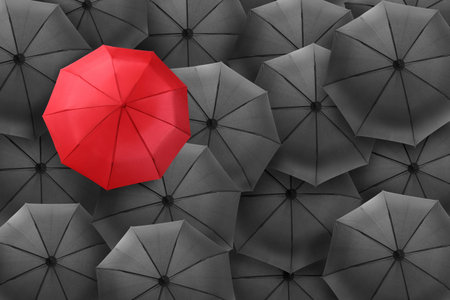 Red umbrella among black ones, top viewの写真素材