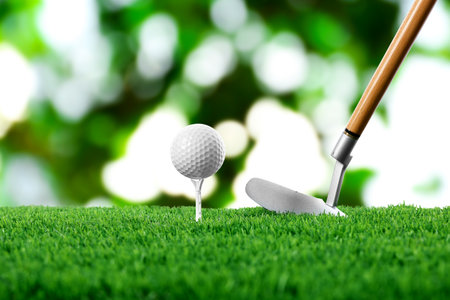 Golf ball on green grass and club outdoors, closeupの写真素材