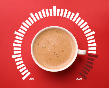 Coffee and power gauge scale on red background, top view. Handle of cup pointing at maximum area. Energizing property of caffeineの写真素材