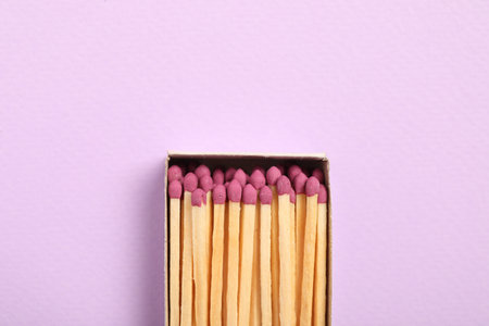 Matches in open box on violet background, top view. Space for textの写真素材