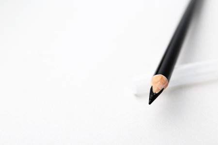 Black eyebrow pencil on light background, closeup. Space for textの写真素材