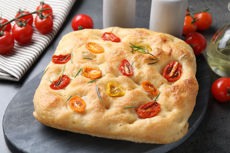 Delicious focaccia with tomatoes and rosemary on gray table, closeupの写真素材