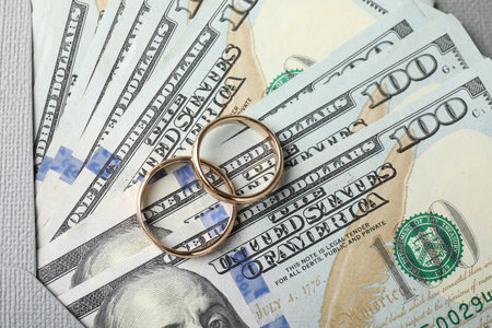 Two gold wedding rings, dollar banknotes and envelope, top viewの写真素材