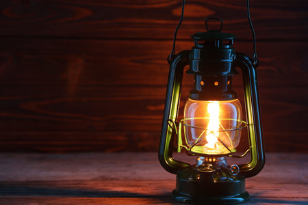 One vintage kerosene lantern on wooden table, space for text