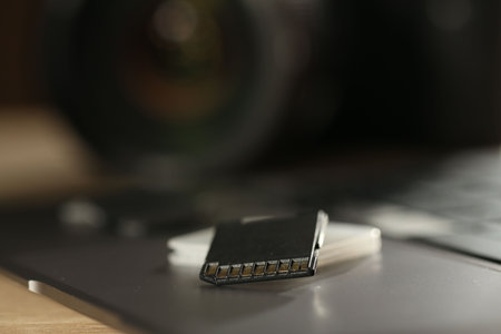 SD memory cards, holder and laptop on table, closeup