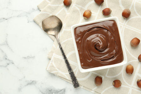 Tasty chocolate spread and hazelnuts on table, flat lay. Space for textの写真素材
