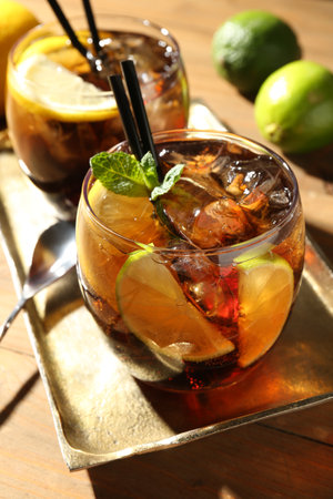 Refreshing Cuba libre cocktail with mint on wooden table, closeupの写真素材