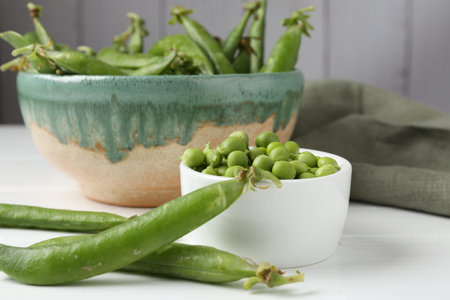 Fresh ripe green peas on white wooden table, closeup