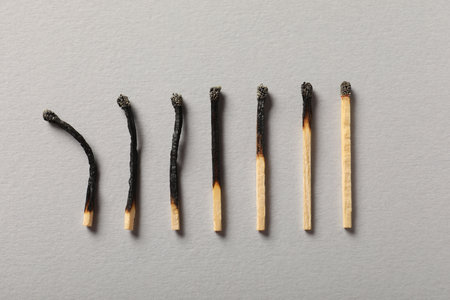 Burnt matches on grey background, flat layの写真素材