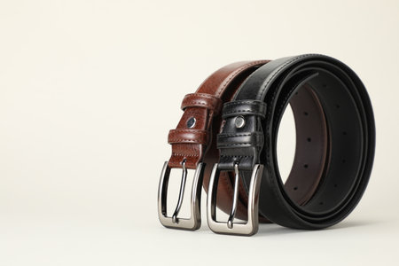 Two leather belts on white background, closeup. Space for textの写真素材