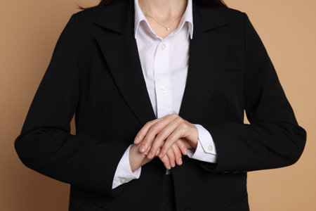 Woman in suit on beige background, closeupの写真素材