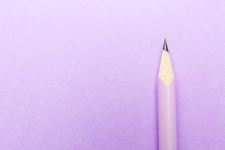 One graphite pencil on violet background, top view. Space for textの写真素材