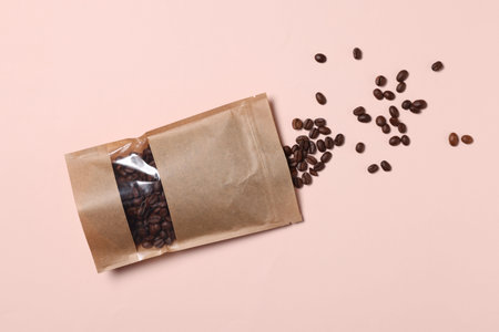 One zipper stand-up pouch with coffee beans on pink background, flat lay. Mockup for designの写真素材