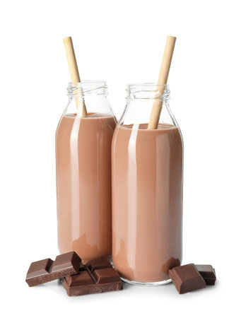 Tasty chocolate milk in glass bottles and pieces isolated on whiteの写真素材