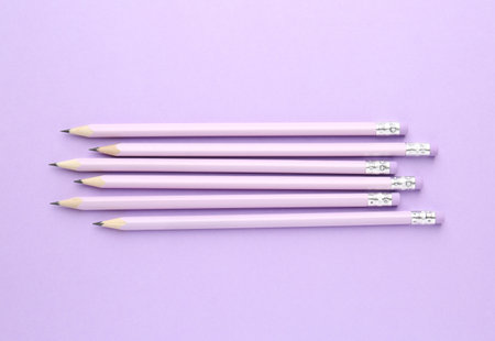Many graphite pencils with erasers on violet background, flat layの写真素材