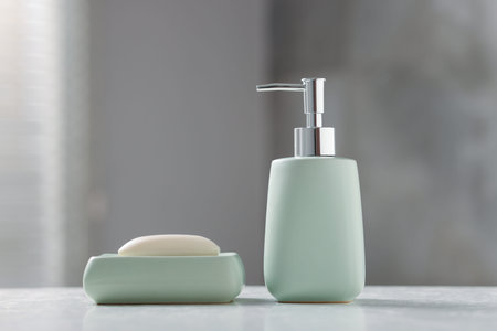 Soap bar and bottle of cosmetic product on white table indoors