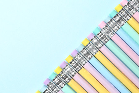 Graphite pencils with erasers on light blue background, flat lay. Space for textの写真素材
