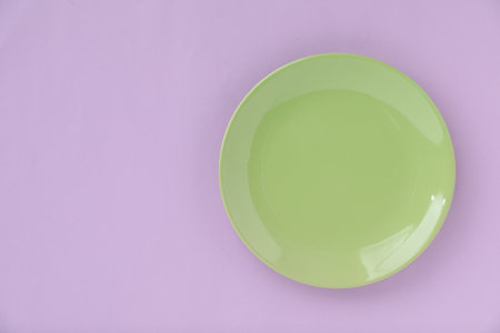 One empty plate on violet background, top view. Space for textの写真素材