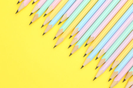Many graphite pencils on yellow background, flat lay. Space for textの写真素材