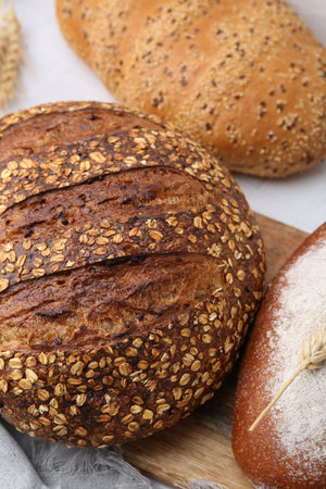 Fresh bread loaves on white table, flat layの写真素材