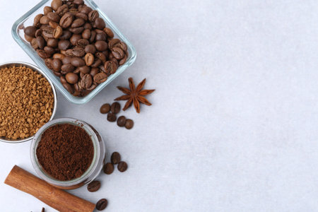 Different types of instant coffee, beans and spices on light table, flat lay. Space for textの写真素材