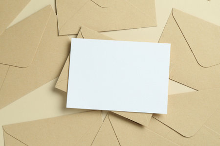 Blank invitation card and envelopes on beige background, flat lay. Space for designの写真素材