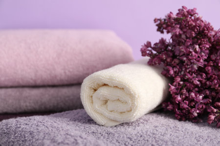 Soft towels and lilac flowers on violet background, closeupの写真素材