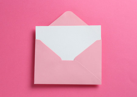 Blank invitation card and envelope on pink background, top viewの写真素材