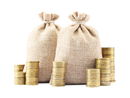 Bags and stacked coins isolated on whiteの写真素材