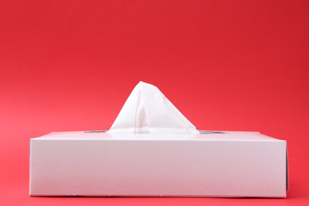 Box with paper handkerchiefs on red background. Space for textの写真素材