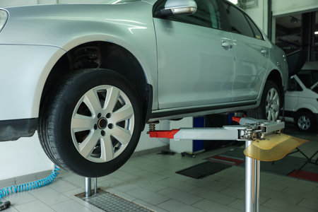 Lifted automobile during tire change at car serviceの写真素材