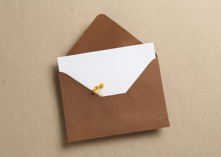 Blank invitation card with flowers and envelope on carton, top viewの写真素材