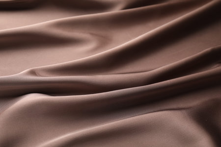 Crumpled light brown silk fabric as background, closeupの写真素材