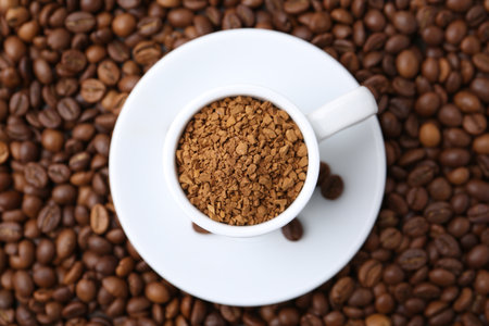 Cup with granulated instant coffee on beans, top viewの写真素材