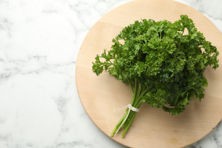 Bunch of fresh parsley on white marble table, top view. Space for text