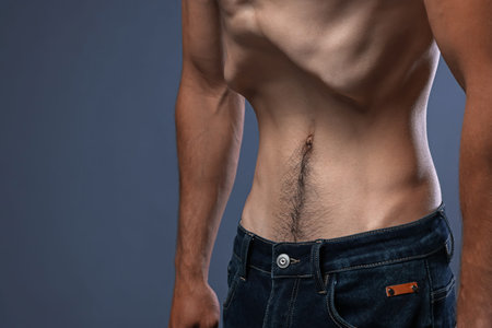 Man suffering from anorexia on grey background, closeup. Space for textのeditorial素材