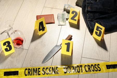 Forensic expertise. Crime scene with evidence, markers and police tape on floorの写真素材