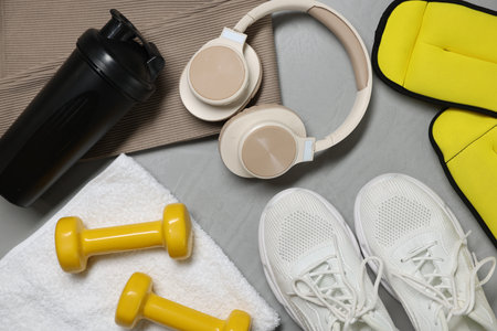 Sportswear, sneakers, headphones and other accessories on gray textured background, flat layの写真素材