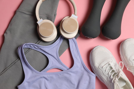 Sportswear, dumbbells, headphones and sneakers on pink background, flat layの写真素材