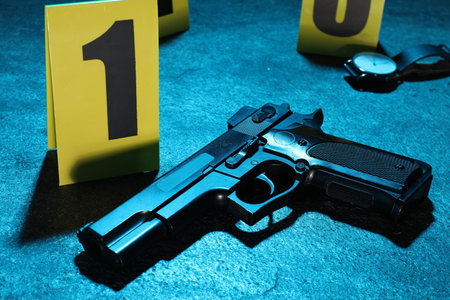 Forensic expertise. Crime scene with evidence, markers and police tape on blue background, closeup. Color toned effectの写真素材