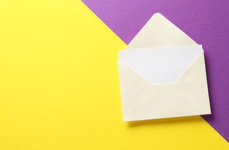 Blank invitation card and envelope on color background, top view